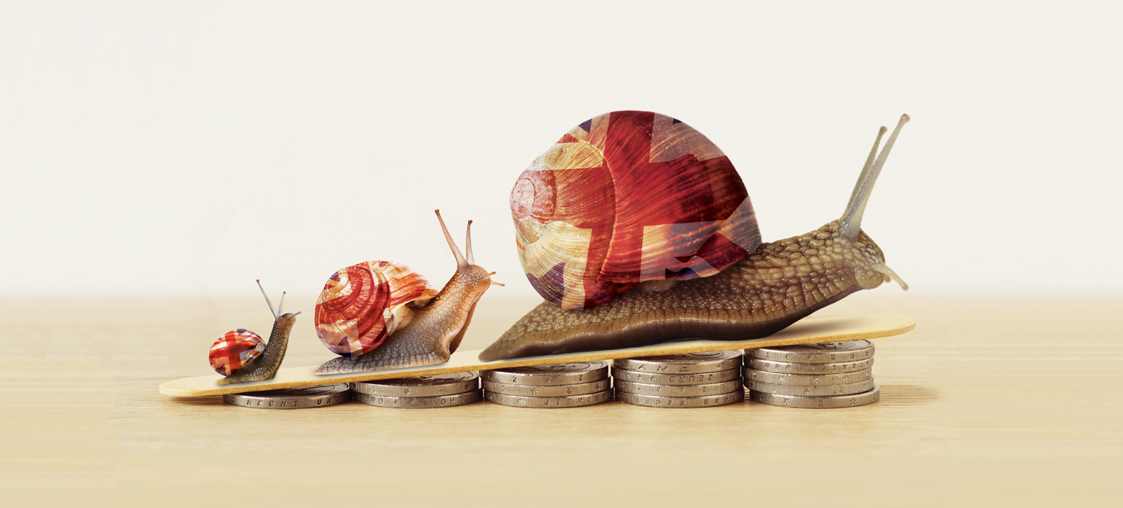 Three progressively larger snails with Union Jack flags on their shells climb a slope the is elevated by piles of pound coins (sterling).