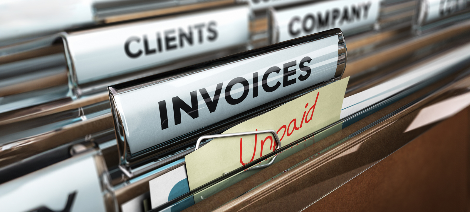 A close up photograph of a file of unpaid invoices in a small company's filing cabinet