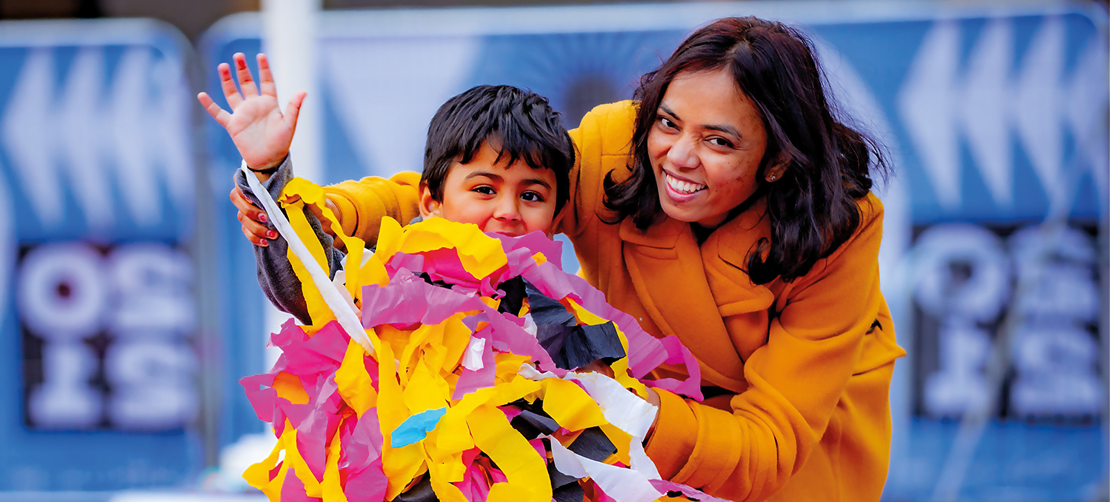 A mother and son hold paper streamers as they enjoy a community event as part of Coventry City of Culture 2021