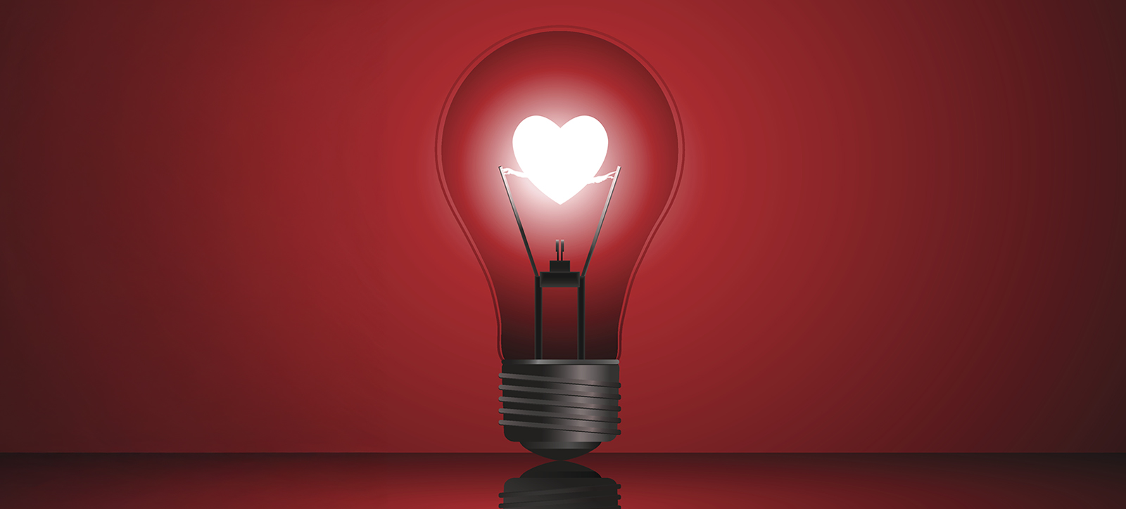 An image of a light bulb with a glowing filament in the shape of a heart. The bulb is stood upright, lit up in the manner often used to signify an idea.