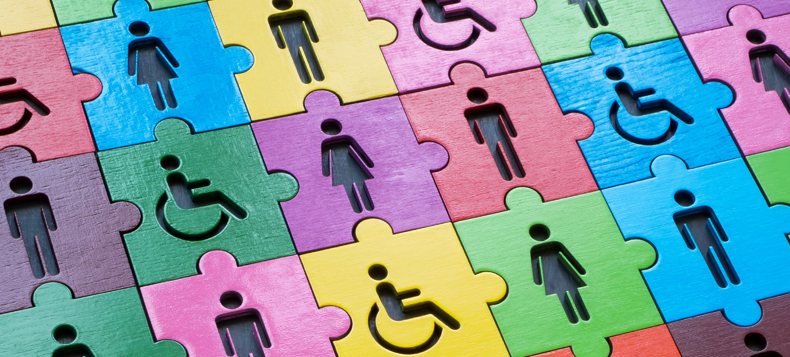 A jigsaw of different coloured tiles showing male, female, and disabled workers, representing diversity and inclusion in the workplace.