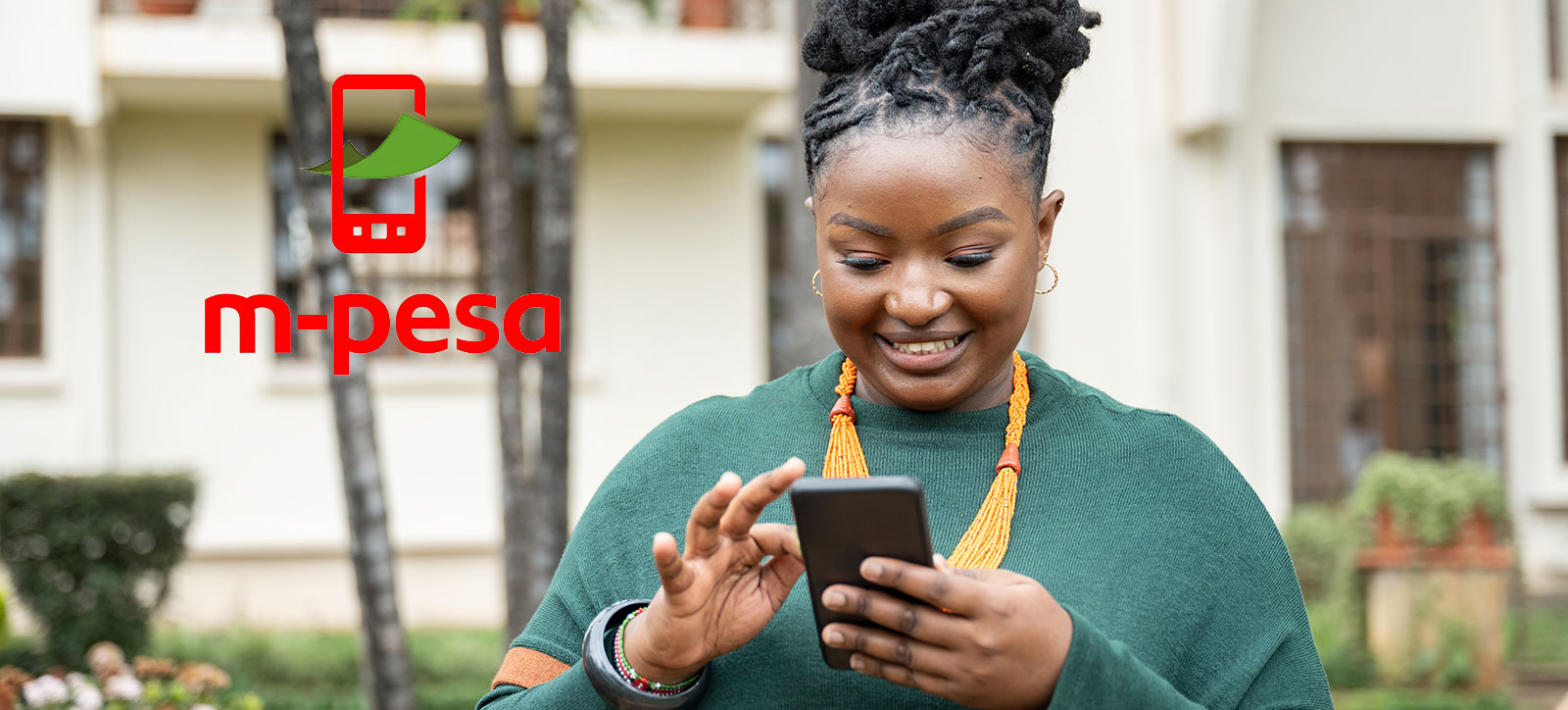 A Kenyan woman uses the M-PESA mobile payment platform on her phone