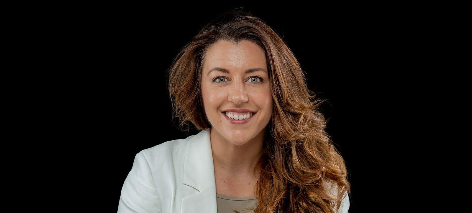 A photograph of Warwick Business School Change Maker Sophie Pullen set against a black backdrop. Sophie is supporting more women in executive roles as Senior Vice President of WeQual